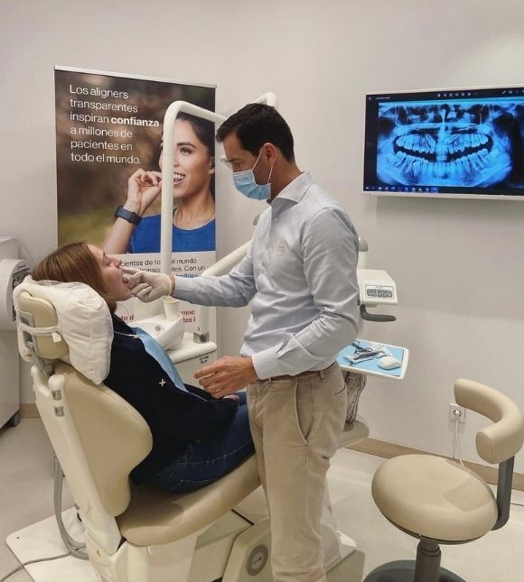 Dr Carlos Raga de KIMO colococando alineadores transparentes a una paciente