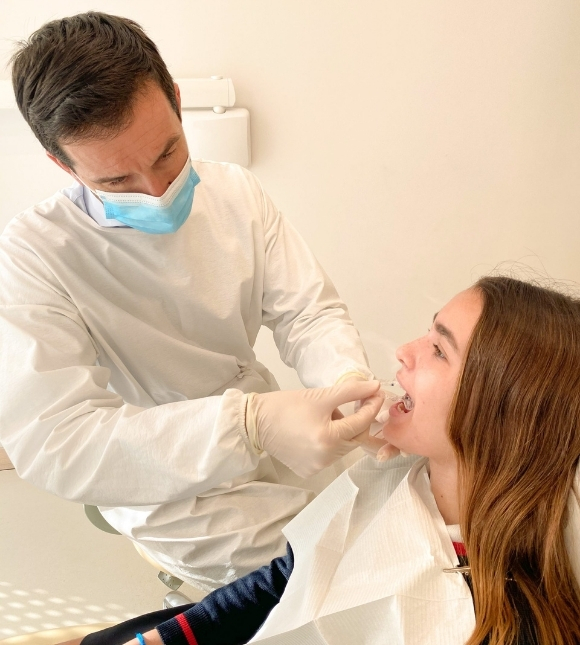 Dr Carlos Raga de KIMO colococando alineadores transparentes a una paciente